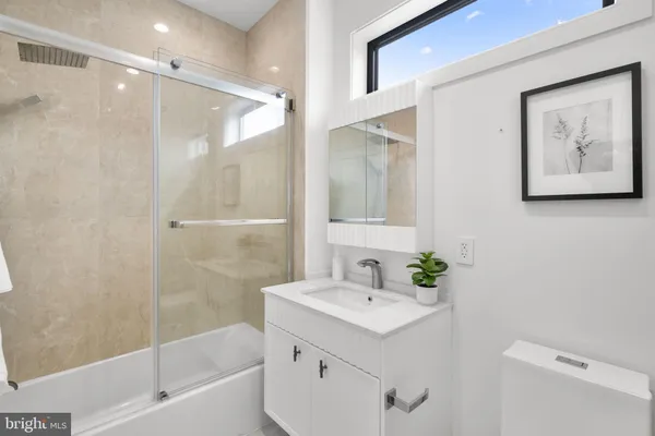 a bathroom with a sink mirror and a shower