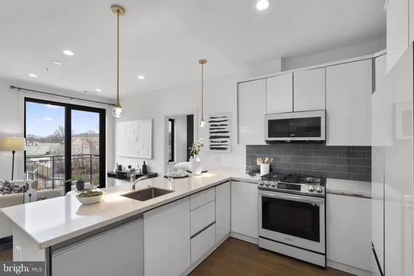 a kitchen with stainless steel appliances a sink stove and microwave