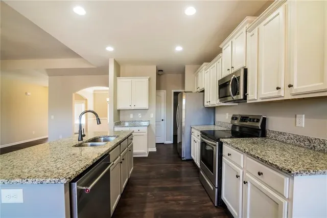 a kitchen with stainless steel appliances granite countertop a stove top oven a sink and dishwasher