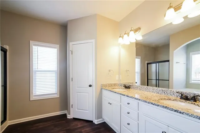 a bathroom with a granite countertop sink and a mirror