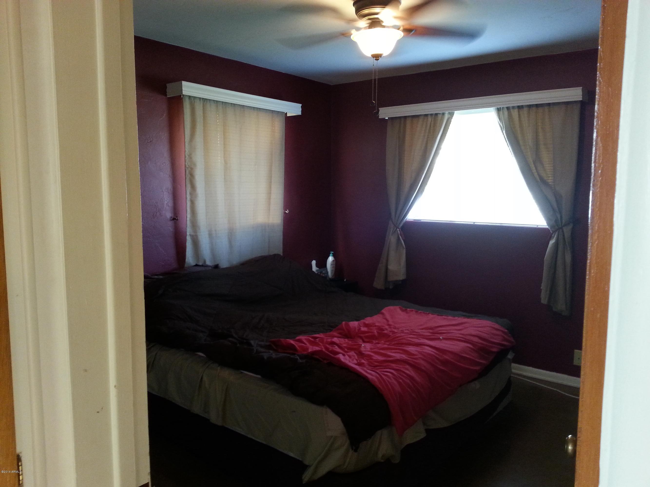 3337 East Granada Road Phoenix, AZ 85008 - Photo 14 of 22 a bedroom with a bed and a chandelier