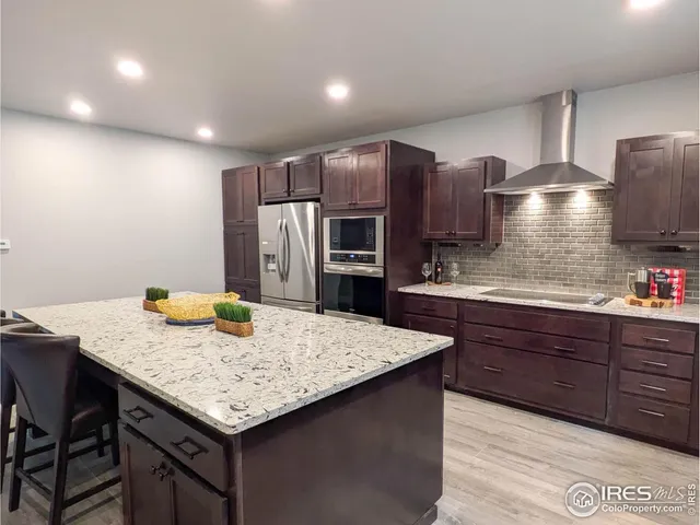 a kitchen with stainless steel appliances granite countertop a kitchen island a cabinets and wooden floor