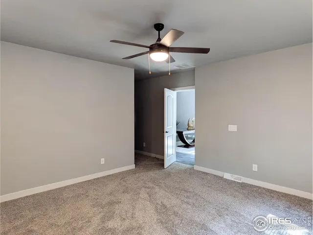 a view of an empty room and a ceiling fan