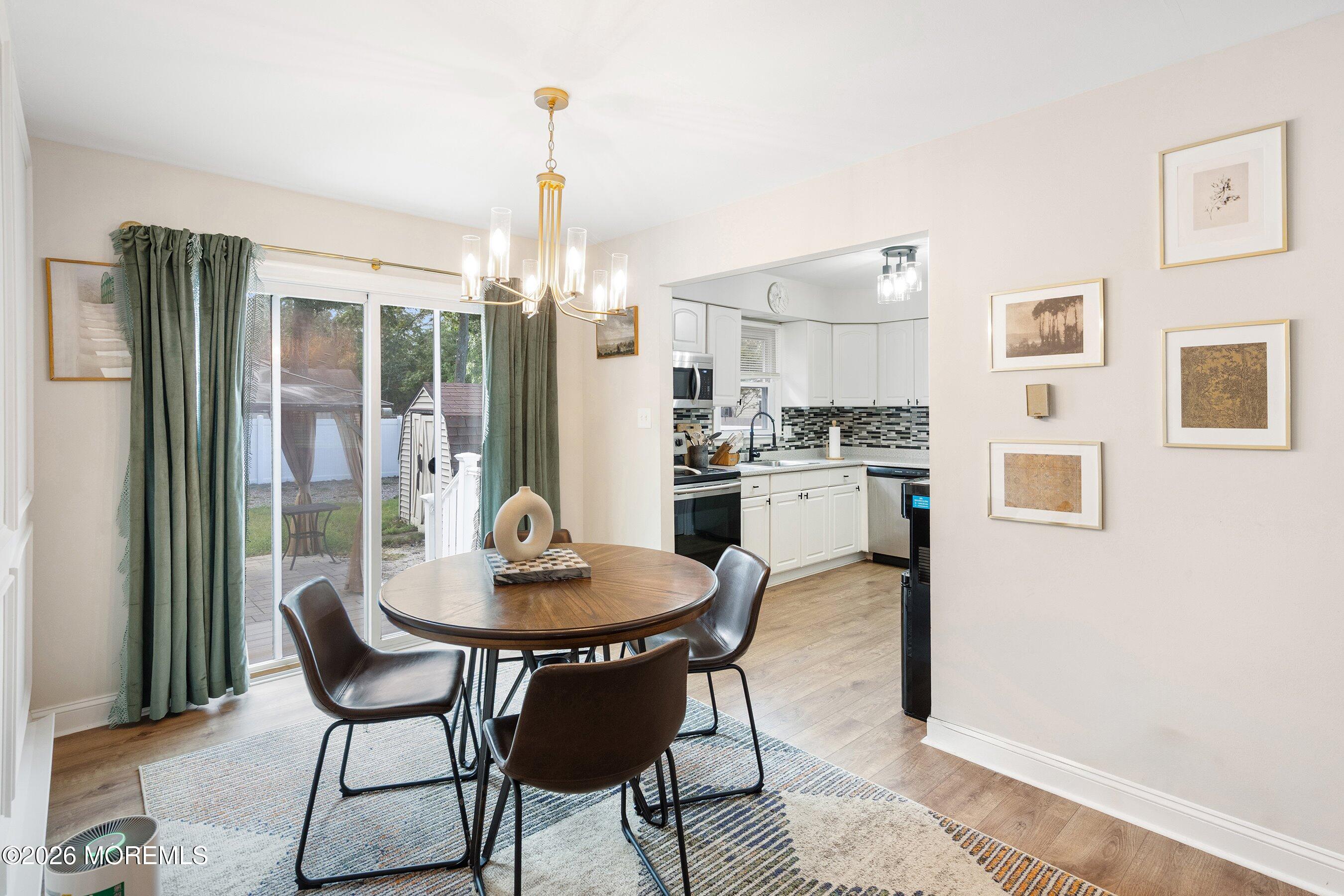329 Briggs Avenue Forked River, NJ 08731 - Photo 5 of 16 a dining room with furniture a chandelier and wooden floor