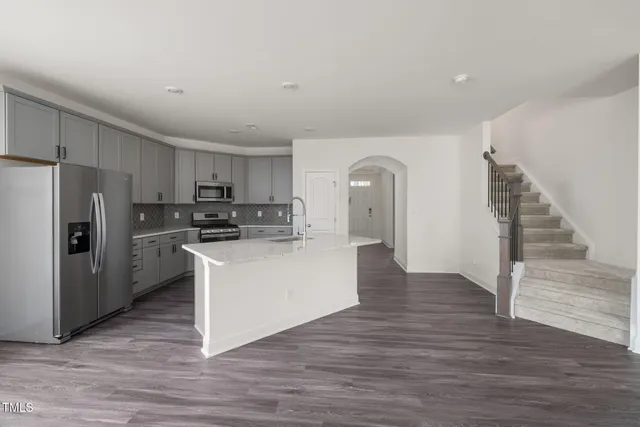 a kitchen with stainless steel appliances a refrigerator and a stove top oven