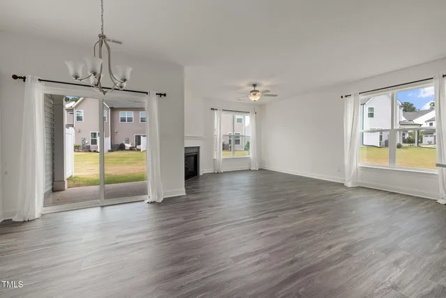 a view of empty room with wooden floor and windows