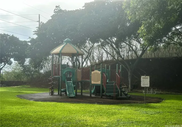 a front view of a house with garden and trees