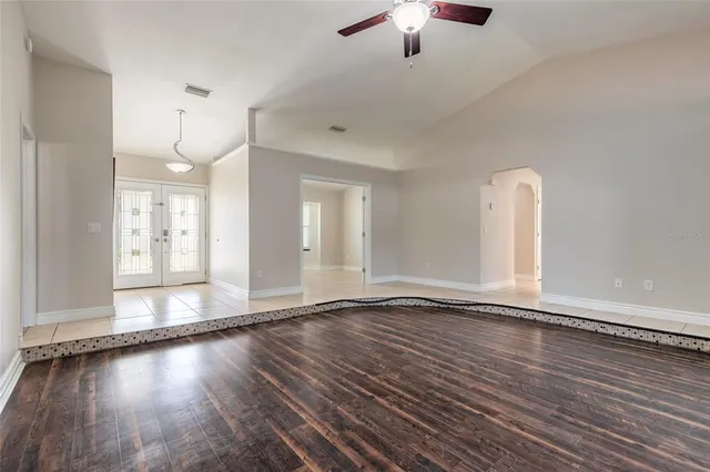 an empty room with wooden floor and window