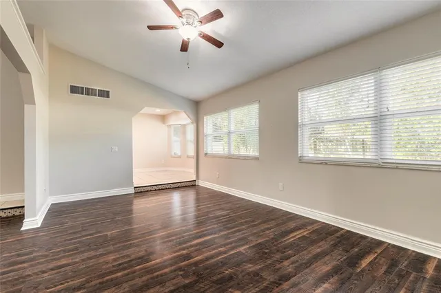 a view of an empty room with a window and wooden floor