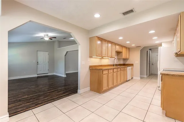 a kitchen with stainless steel appliances kitchen island granite countertop a refrigerator and a stove top oven