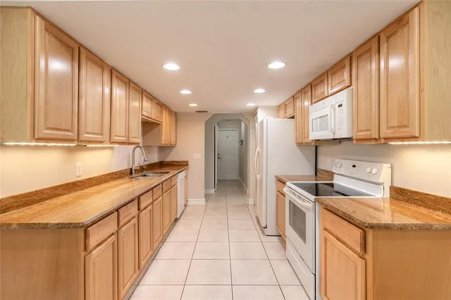 a kitchen with stainless steel appliances granite countertop a sink a stove and a refrigerator