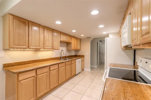 a large kitchen with stainless steel appliances kitchen island granite countertop a sink and cabinets