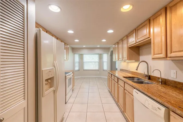 a kitchen with stainless steel appliances granite countertop a sink and cabinets with wooden floors