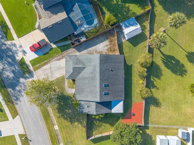 an aerial view of a house with swimming pool and large trees