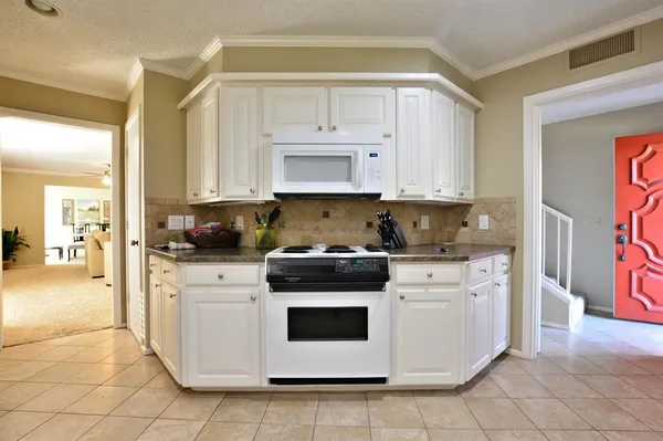 a kitchen with stainless steel appliances granite countertop a stove a white and a refrigerator