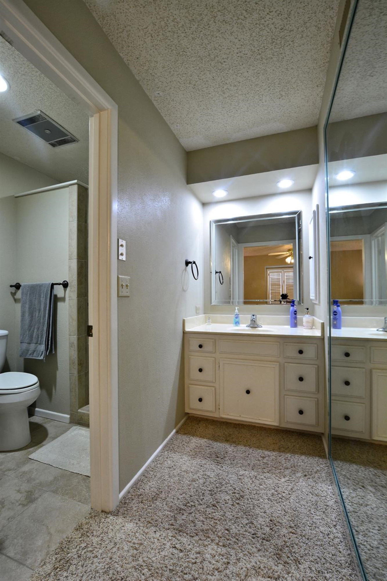 3307 74th Street, Unit A Lubbock, TX 79423 - Photo 9 of 19 a bathroom with a sink a toilet and a large mirror