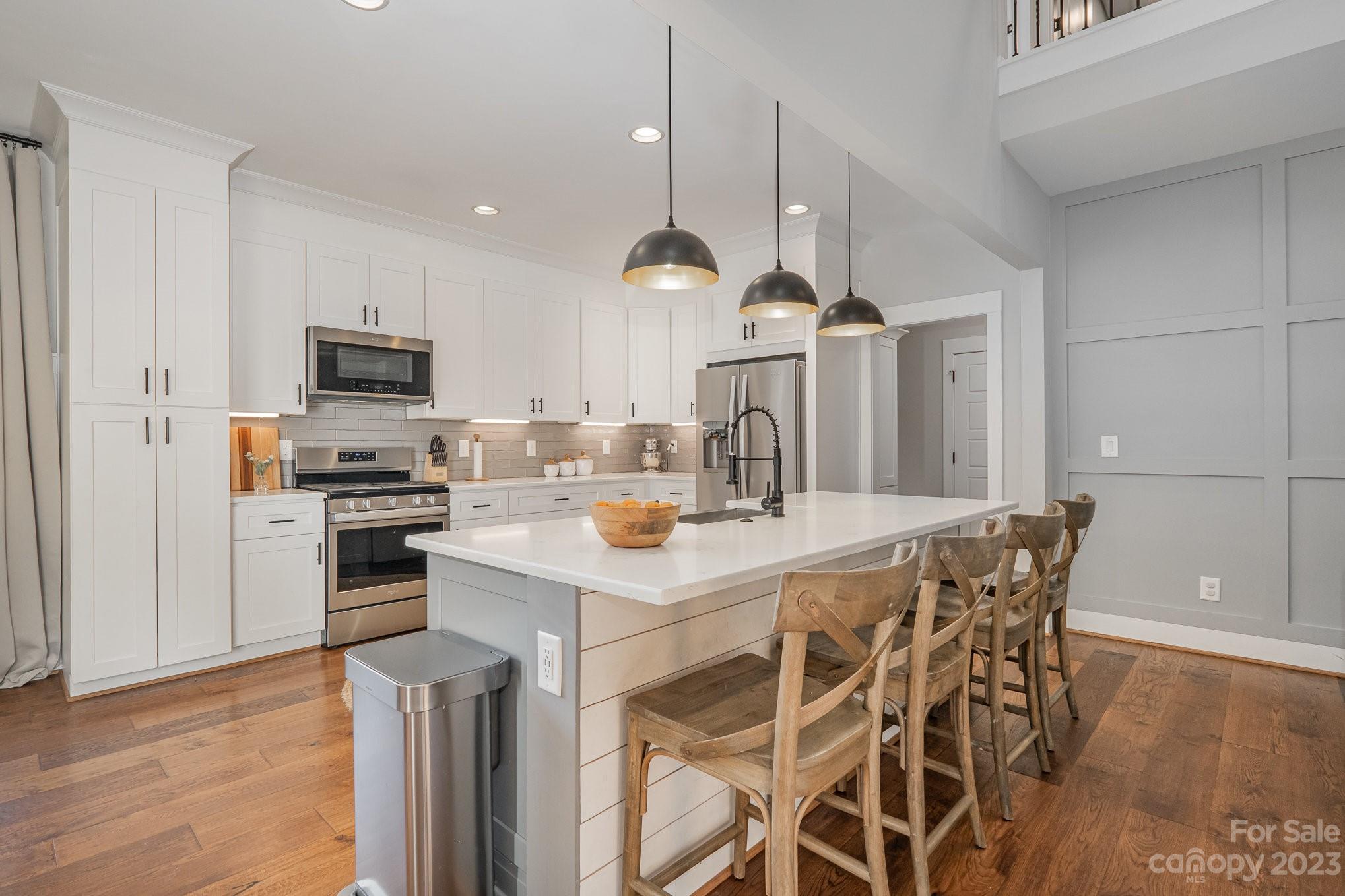 1007 Flat Rock Drive Monroe, NC 28110 - Photo 11 of 34 a kitchen with a dining table chairs stainless steel appliances and wooden floor