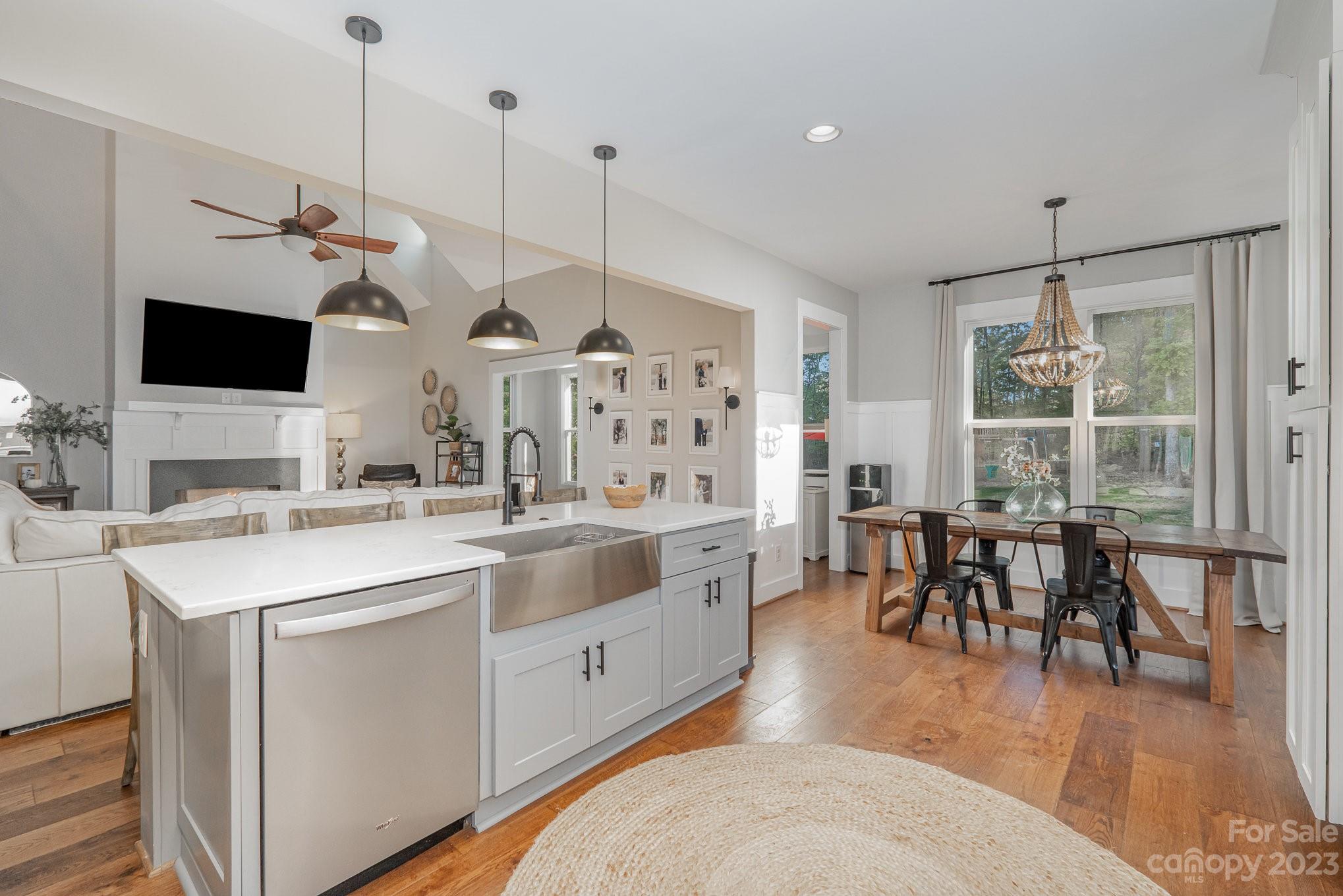 1007 Flat Rock Drive Monroe, NC 28110 - Photo 13 of 34 a open kitchen with stainless steel appliances kitchen island granite countertop a stove a sink a dining table and chairs with wooden floor