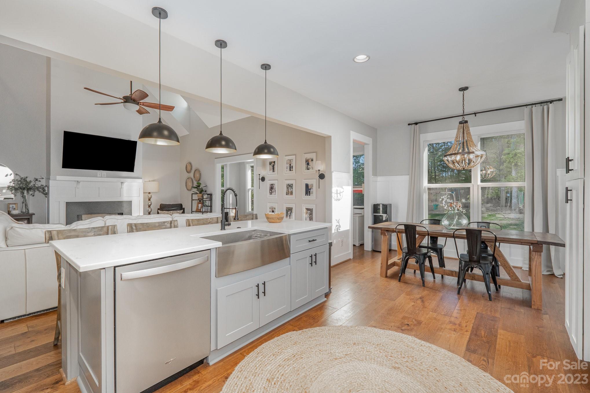 1007 Flat Rock Drive Monroe, NC 28110 - Photo 8 of 34 a open kitchen with stainless steel appliances kitchen island granite countertop a stove a sink a dining table and chairs with wooden floor