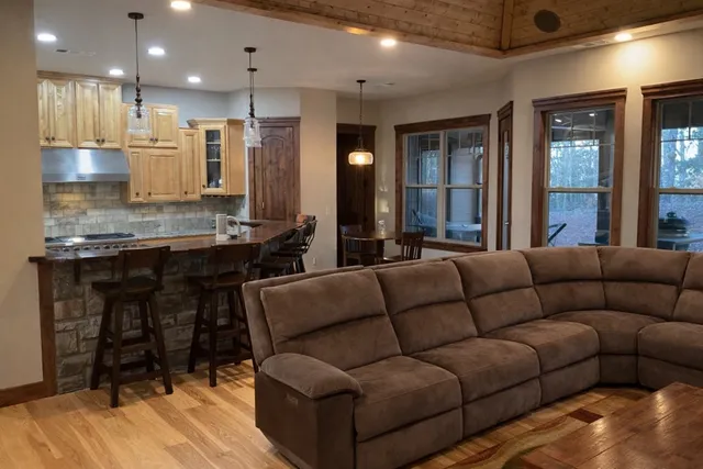 a living room with furniture kitchen and a wooden floor