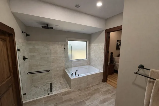 a bathroom with a tub sink and mirror