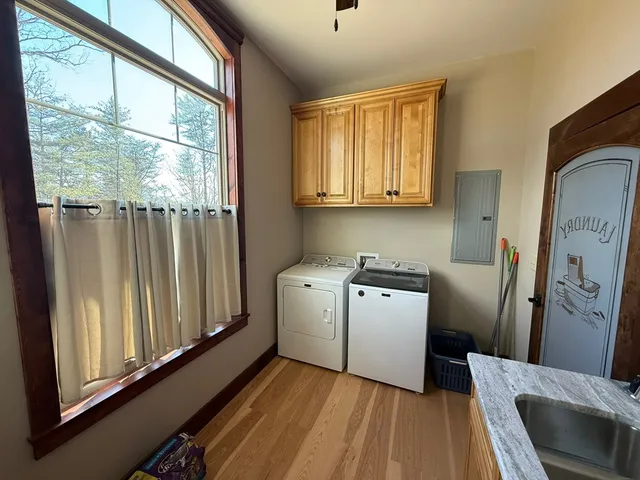 a utility room with wooden floor washer and dryer