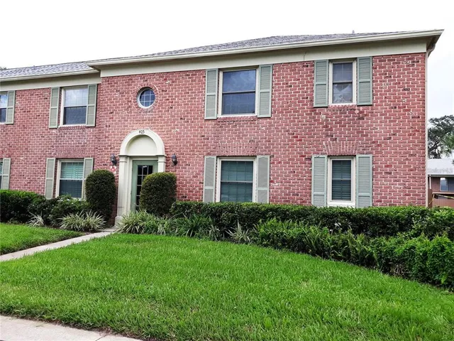 a front view of a house with garden and garage
