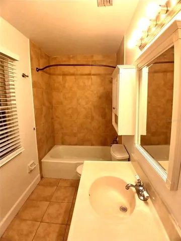 a bathroom with a tub shower and sink