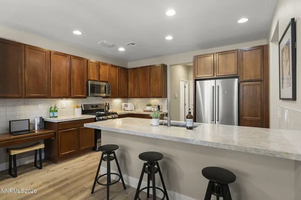a kitchen with kitchen island granite countertop a sink stove and refrigerator