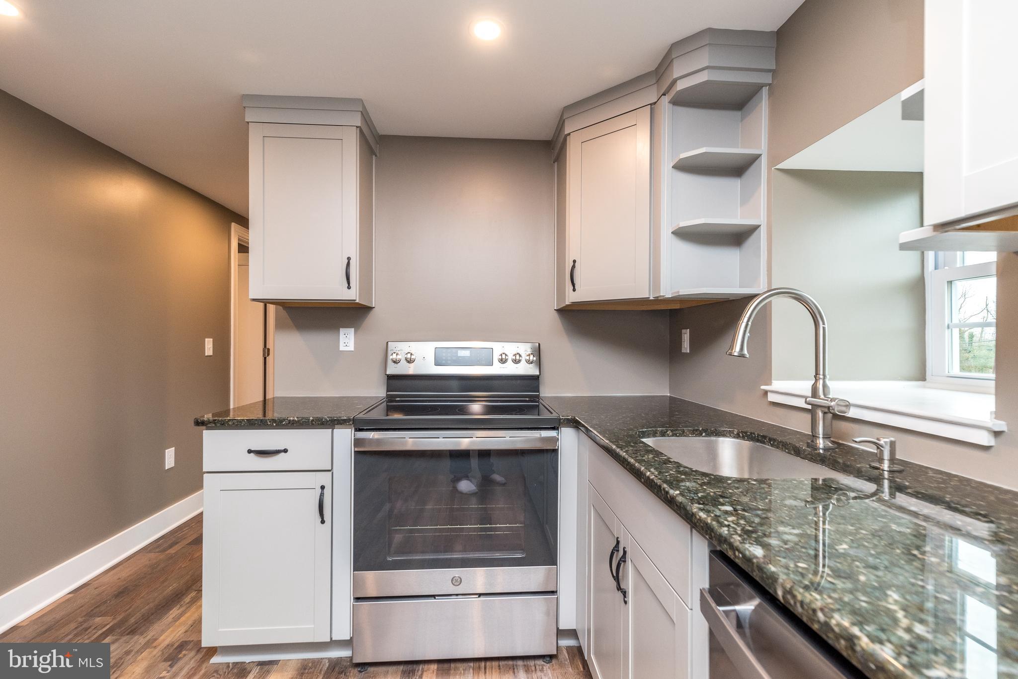 4844 Old Easton Road, Unit 2 Doylestown, PA 18902 - Photo 18 of 33 a kitchen with granite countertop a sink stove and cabinets