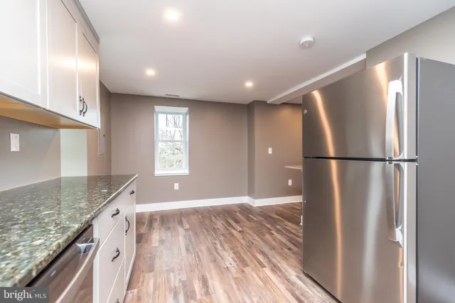 a kitchen with granite countertop a refrigerator and a sink