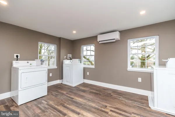 a room with a washer and dryer with wooden floor