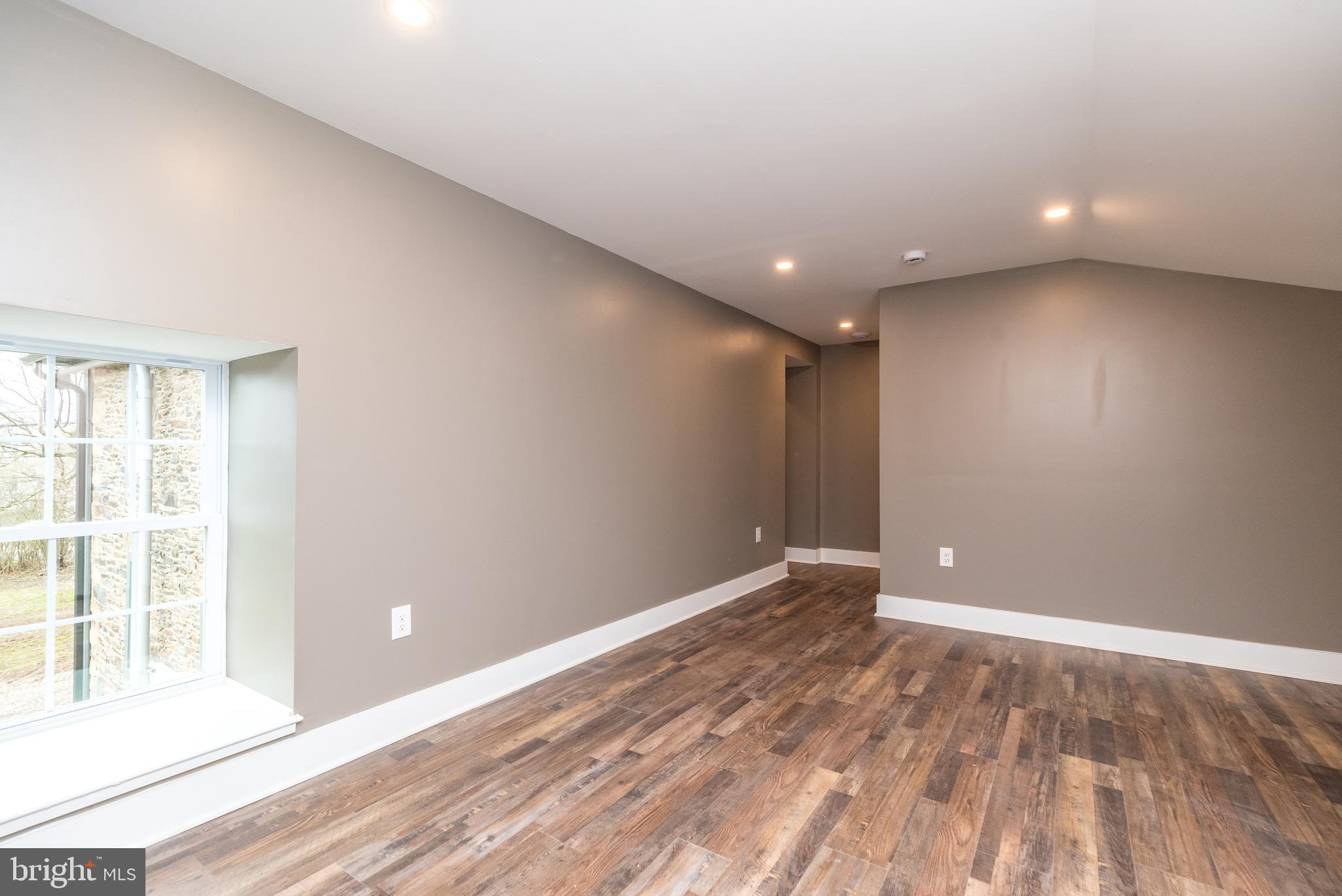 4844 Old Easton Road, Unit 2 Doylestown, PA 18902 - Photo 8 of 33 an empty room with wooden floor and windows