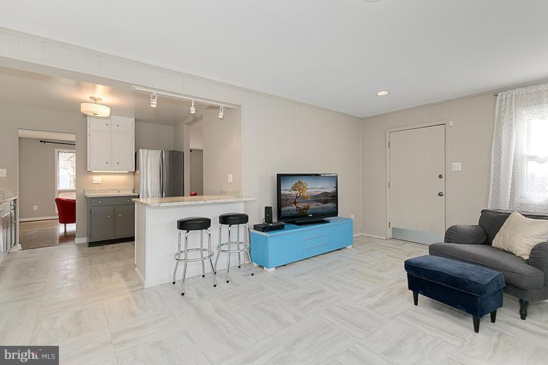12912 Holdridge Road Silver Spring, MD 20906 - Photo 5 of 25 a living room with furniture and a flat screen tv