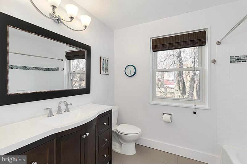 12912 Holdridge Road Silver Spring, MD 20906 - Photo 10 of 25 a bathroom with a toilet a sink a mirror and a window