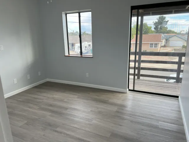 an entryway with wooden floor and a mirror