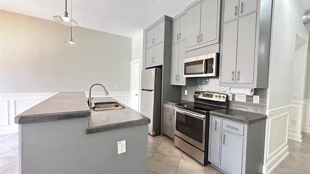 a kitchen with stainless steel appliances granite countertop white cabinets a microwave oven a sink and dishwasher