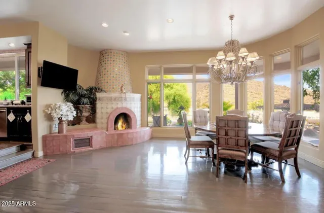 a view of a dining room with furniture a chandelier and large windows