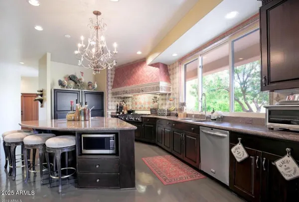 a kitchen with stainless steel appliances kitchen island granite countertop furniture and a dining table