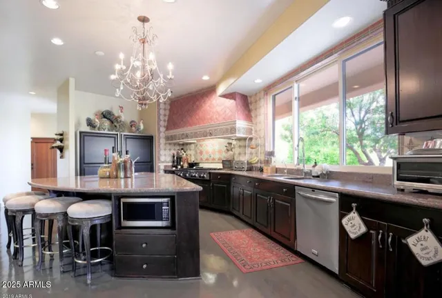 a kitchen with stainless steel appliances kitchen island granite countertop furniture and a dining table