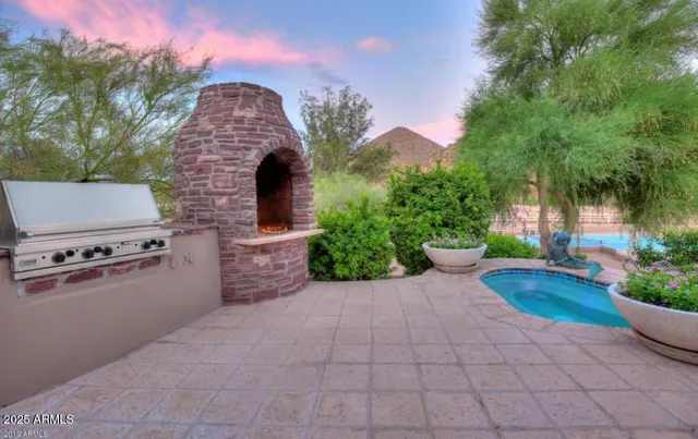 a view of a patio with couches and table and chairs with wooden fence and plants