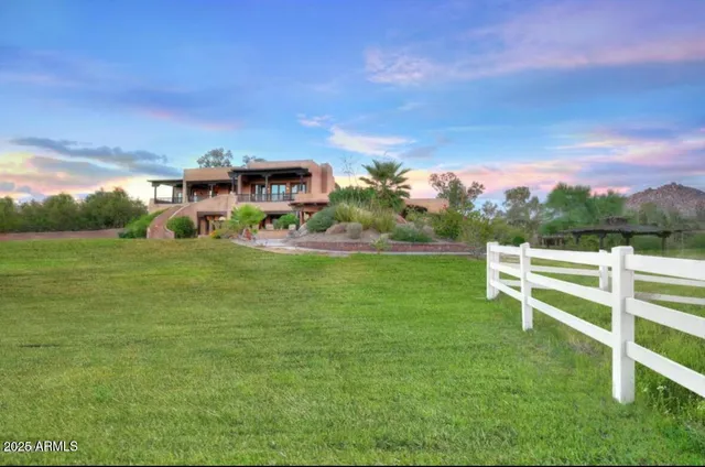 a view of a patio with couches and table and chairs with wooden fence and plants