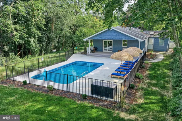 a living room with patio furniture and floor to ceiling windows