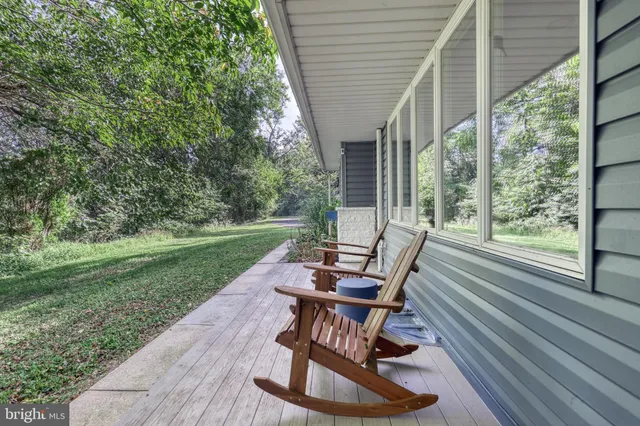 a view of backyard with outdoor seating and trees in the background