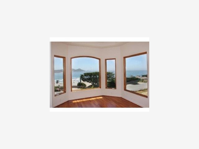 a picture of a living room with a floor to ceiling window and a fireplace