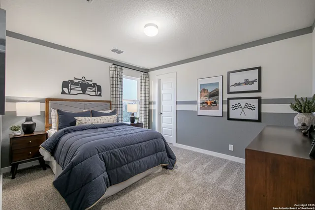 a bedroom with a lamp beds and painting on the wall