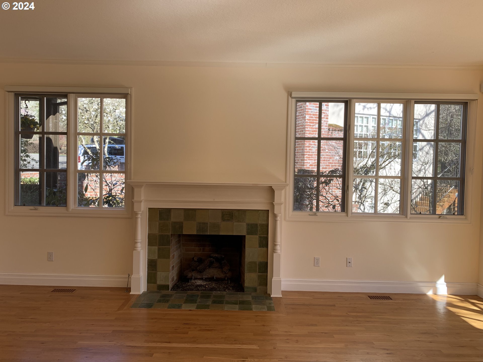 9916 Northwest Abbey Road Portland, OR 97229 - Photo 13 of 48 a living room with a fireplace and a floor to ceiling window