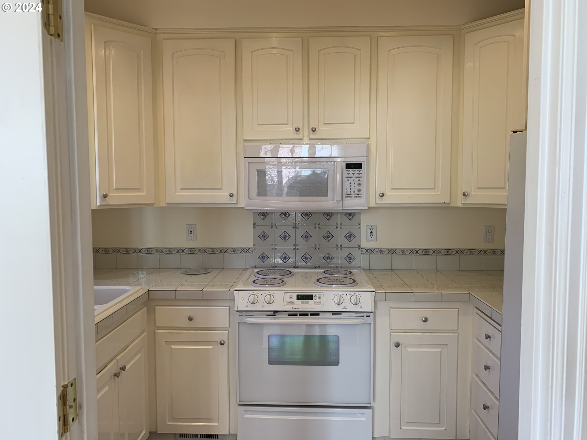 9916 Northwest Abbey Road Portland, OR 97229 - Photo 18 of 48 a kitchen with stainless steel appliances granite countertop white cabinets and a stove