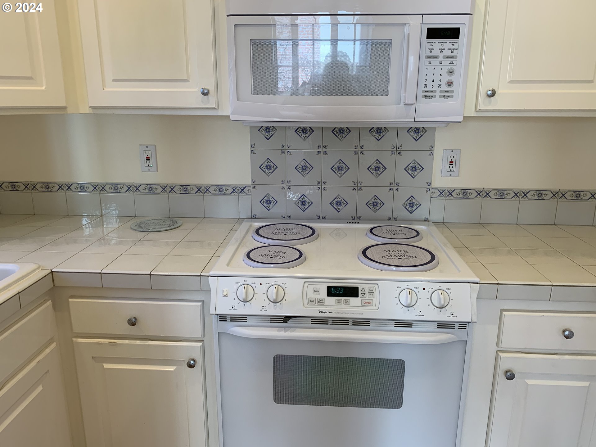 9916 Northwest Abbey Road Portland, OR 97229 - Photo 19 of 48 a kitchen with a stove and white cabinets