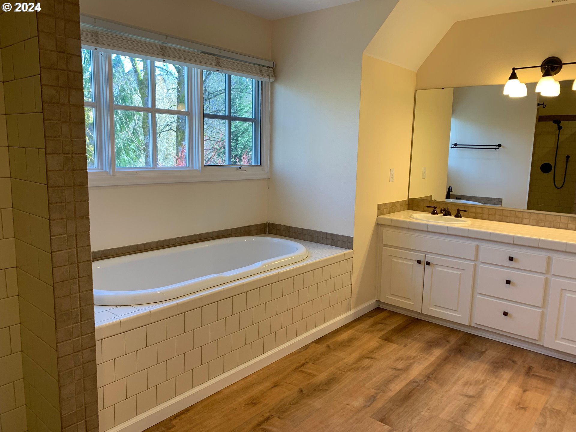 9916 Northwest Abbey Road Portland, OR 97229 - Photo 34 of 48 a bathroom with a tub sink and mirror